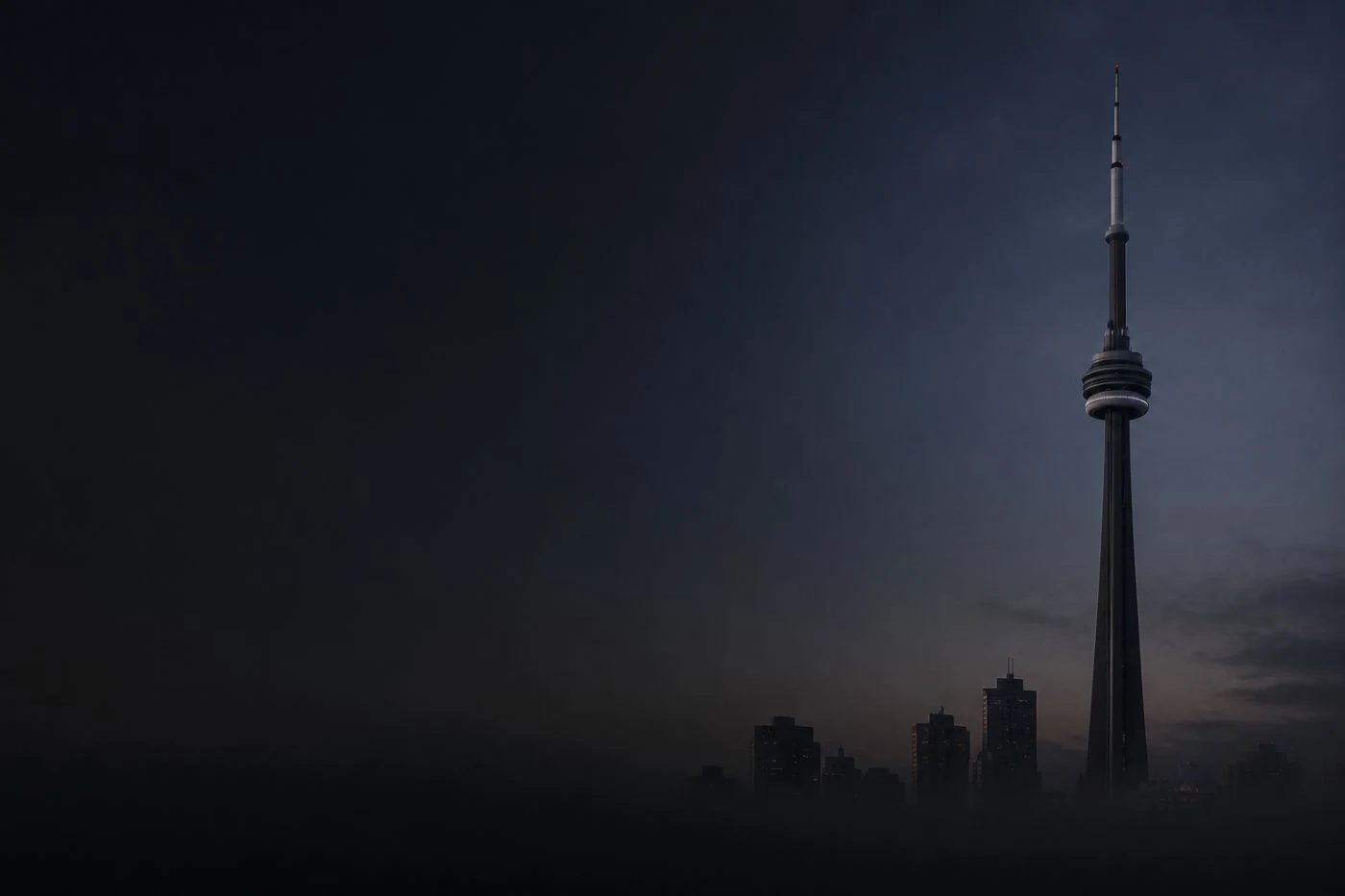 The CN Tower emerging from fog above the Toronto skyline